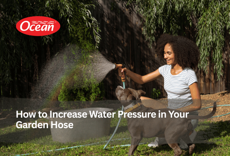 Girl playing with dog using garden hose with strong water pressure in backyard