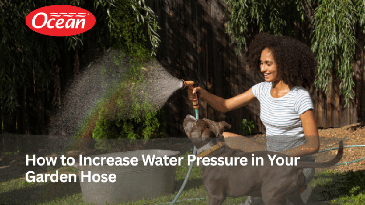 Girl playing with dog using garden hose with strong water pressure in backyard